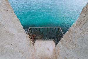 een uitzicht op de oceaan vanaf de top van een klif bij Tre Archi Suite & Relais in Polignano a Mare