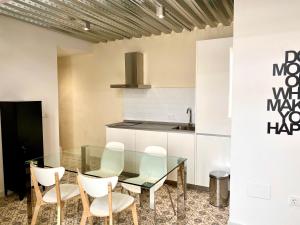 une cuisine avec une table en verre et des chaises blanches dans l'établissement Loft Jerez Centro, à Jerez de la Frontera