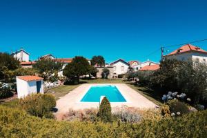 a house with a swimming pool in a yard at Villa Oliveira in Melo