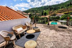 a patio with chairs and tables and a pool at Villa Oliveira in Melo
