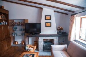 a living room with a tv and a fireplace at Villa Oliveira in Melo