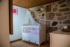 a crib in a room with a stone wall at Villa Oliveira in Melo +43 photos