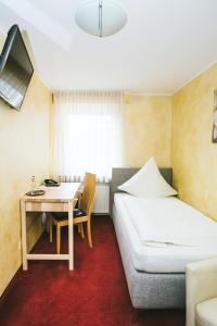 a bedroom with a bed and a desk and a table at Schultes Landhaus in Delbrück