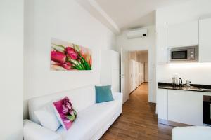 uma sala de estar branca com um sofá branco e uma pintura na parede em White Loft Como Central - The House Of Travelers em Como