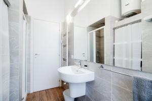 une salle de bain blanche avec un lavabo et un miroir dans l'établissement White Loft Como Central - The House Of Travelers, à Côme 32 autres photos