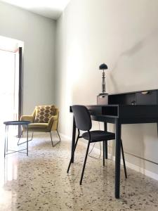 een zwarte piano in een woonkamer met een stoel bij Dimora San Camillo in Catania