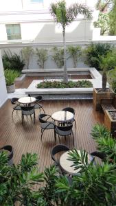 un patio con mesas y sillas en un edificio en Requinte e privacidade em bairro nobre de Curitiba en Curitiba