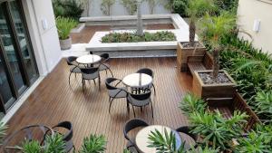 un patio con mesas y sillas en Requinte e privacidade em bairro nobre de Curitiba en Curitiba