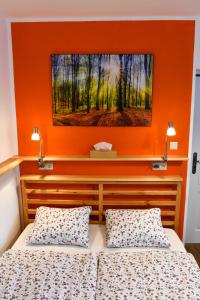 two beds in a room with an orange wall at Nad Zlatým Potokem in Kašperské Hory