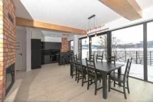 a kitchen and dining room with a table and chairs at The Lake House - dom nad samym Jeziorem Rożnowskim in Znamirowice