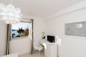 a white room with a desk with a tv and a window at Villa Babilon in Zaton