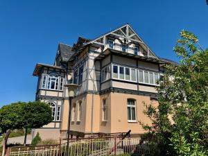 a large house with a blue sky in the background at Villa Frieden Hotel & Seminarhaus in Bad Blankenburg