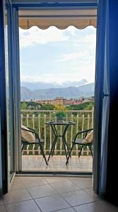een patio met een tafel en 2 stoelen en uitzicht op een veld bij Casa Athena in Sorrento