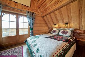 ObidowaにあるJarogówka Stylowy dom góralskiの丸太小屋のベッドのある寝室