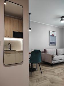 a living room with a couch and a mirror at Apartament Matejki 17 - Insel Apartamenty in Świnoujście