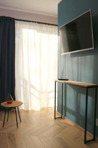 a room with a television and a table and a window at Apartament Matejki 17 - Insel Apartamenty in Świnoujście +54 photos