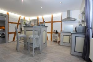 uma cozinha com mesa e cadeiras num quarto em La Maison Oberlin em Horbourg