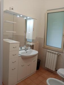 a bathroom with a sink and a mirror and a toilet at AZIENDA AGRICOLA 25 PONTI in Gaeta