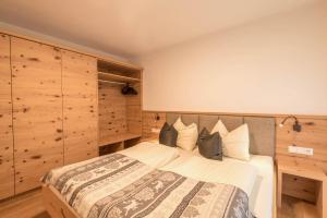 Un dormitorio con una cama grande con paredes de madera. en Apartments Christa App Zirm, en Ortisei