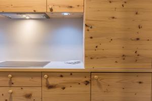 Una cocina con gabinetes de madera y encimera. en Apartments Christa App Zirm, en Ortisei 13 fotos más