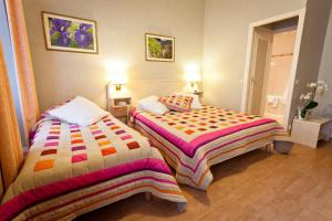 two beds sitting next to each other in a room at hotel les edelweiss in Cauterets