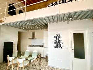 une salle à manger avec une table en verre et des chaises blanches dans l'établissement Loft Jerez Centro, à Jerez de la Frontera
