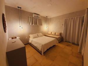 a small bedroom with a bed and a window at Villa Kaitei in São Miguel do Gostoso