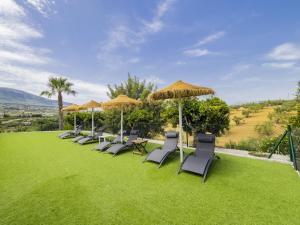 アラウリン・エル・グランデにあるCubo's Villa Los Javielesの芝生の上の椅子・傘