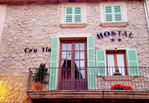 a building with two windows and a sign on the side of it at Hostal Ca'n Tiu in Alaró