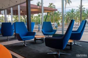 une rangée de chaises bleues dans un bâtiment dans l'établissement Pemba Express Hotel, à Pemba