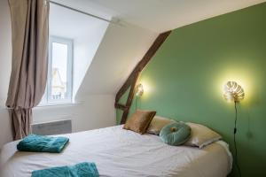 - une chambre avec un lit avec deux oreillers et une fenêtre dans l'établissement Le Teck, à Deauville