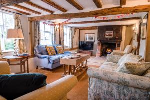 a living room with couches and a fireplace at Lavender Cottage in Saxmundham