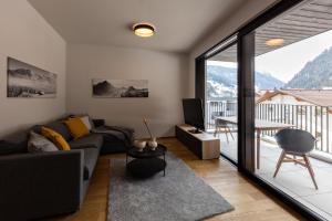 ein Wohnzimmer mit einem Sofa und einem großen Fenster in der Unterkunft Charmantes Apartment in der Residenz Silvretta inkl Silvretta Premium Summer Card in See