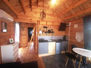 a kitchen in a log cabin with a table and chairs at Sea You Soon w Sztutowie in Sztutowo +26 photos