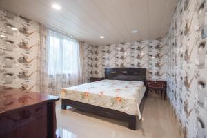 a bedroom with a bed in a room with wallpaper at Cozy apartment near Kobuleti with mountain view in K'obulet'i