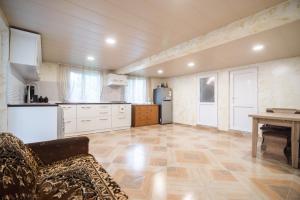 a kitchen with white cabinets and a wooden floor at Cozy apartment near Kobuleti with mountain view in K'obulet'i