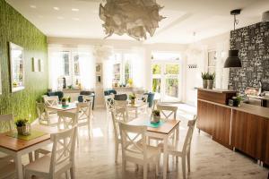 a dining room with tables and chairs and green walls at Dom Wczasowy Kliper in Niechorze