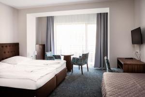 a hotel room with two beds and a table and chairs at Dom Wczasowy Kliper in Niechorze +32 photos
