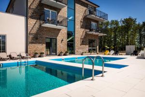 a swimming pool in front of a building at Dom Wczasowy Kliper in Niechorze
