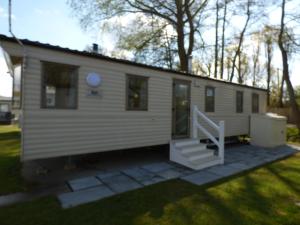 a tiny house with a staircase in a yard at Weeley Lakeview Caravan. in Weeley