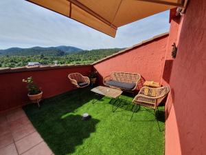 Un balcón con sillas y una mesa con vistas. en Casas Colorín Colorado, en Vilanova de la Reina (Villanueva de Viver)