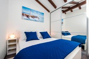 sypialnia z dwoma łóżkami i niebieskimi poduszkami w obiekcie The Attic Rovinj w Rovinj
