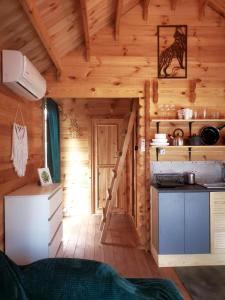 a kitchen in a log cabin with a stove at Sea You Soon w Sztutowie in Sztutowo
