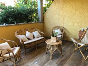 2 sedie in vimini e un tavolo con sedie su un patio di CASA LA TANCA a Isola Rossa