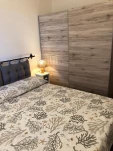 イーゾラ・ロッサにあるCASA LA TANCAのベッドルーム1室(大型ベッド1台、木製ヘッドボード付)
