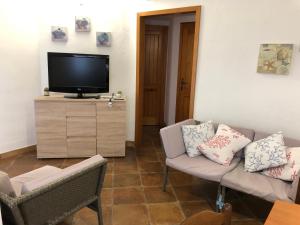 - un salon avec un canapé et une télévision dans l'établissement CASA LA TANCA, à Isola Rossa