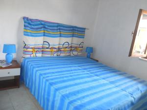 a bedroom with a bed with a blue striped sheet at Sunset Lodge in Paola