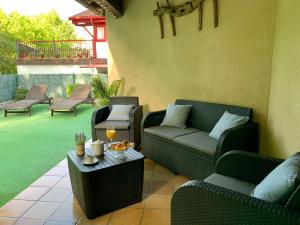 a patio with couches and a table with drinks on it at Apartamento Usuaia con jacuzzi in Lesaka