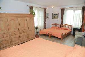 a bedroom with a bed and a large wooden cabinet at Raza Soarelui in Sovata