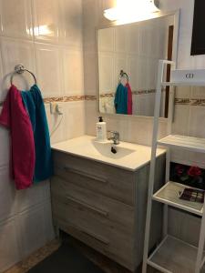 a bathroom with a sink and a mirror at Beach Apartment la Arena in Puerto de Santiago